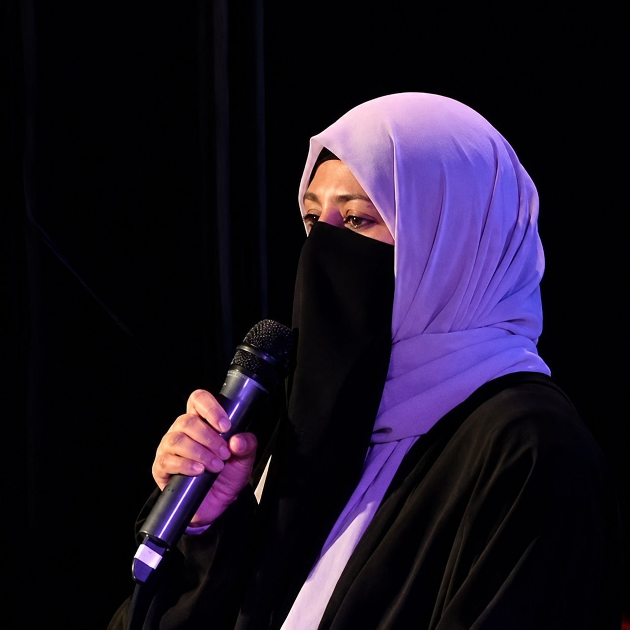 Tahirah Hussain speaking into a microphone
